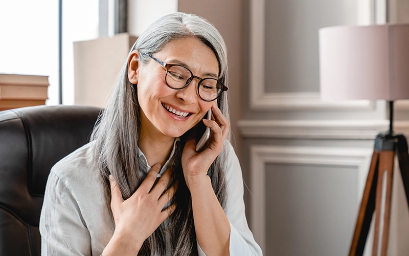 woman smiling and talking on the phone