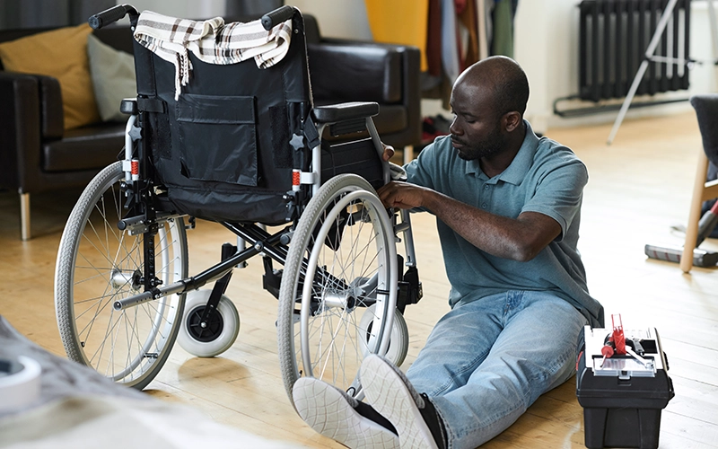 man repairing a wheelchair