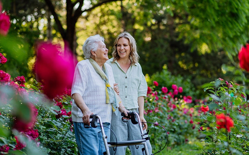 woman walking with a woman using a walker
